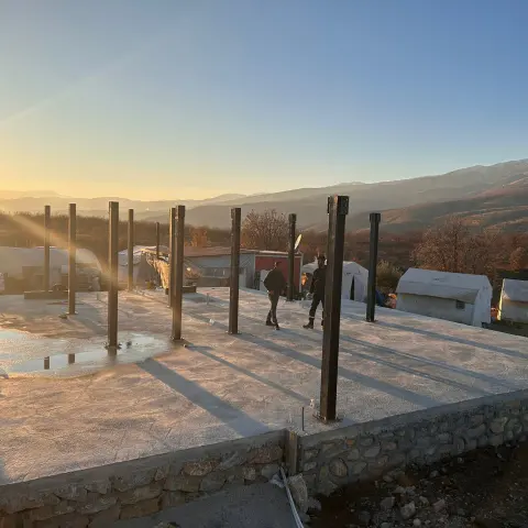 Radye temel üzerinde ankrajlanmış çelik kolonlar, gün batımı