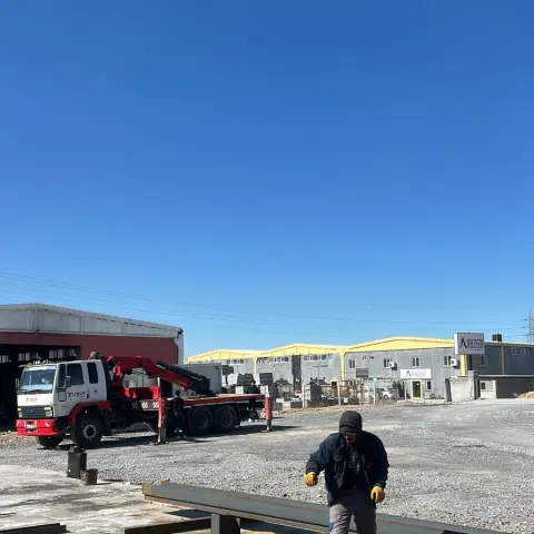 Sahaya indirilen çelik kirişler ve mobil vinç